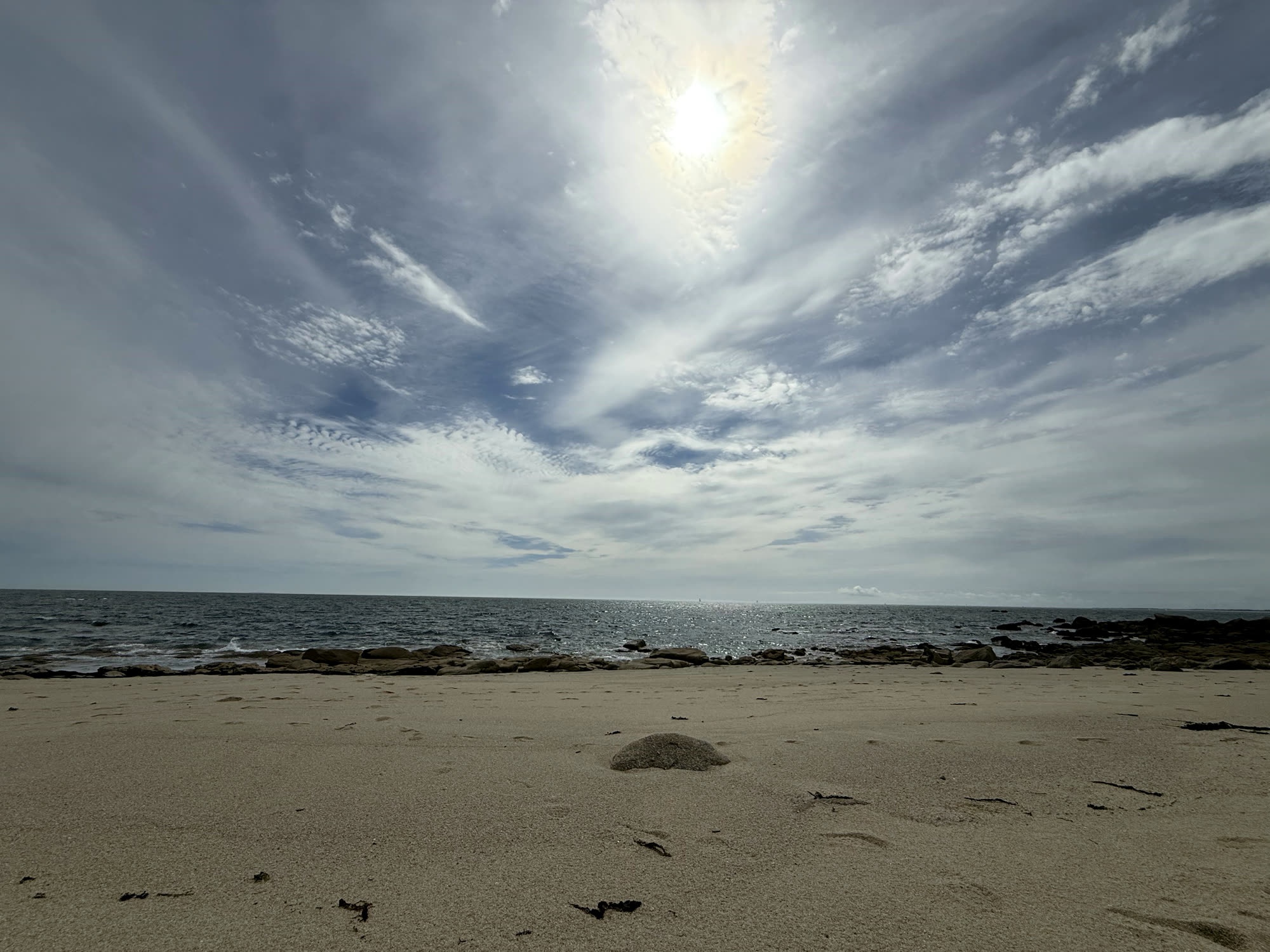 Breiter Sandstrand unter dramatischem Himmel in der Bretagne